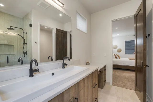 a en suite bathroom with a double tub sink and mirror