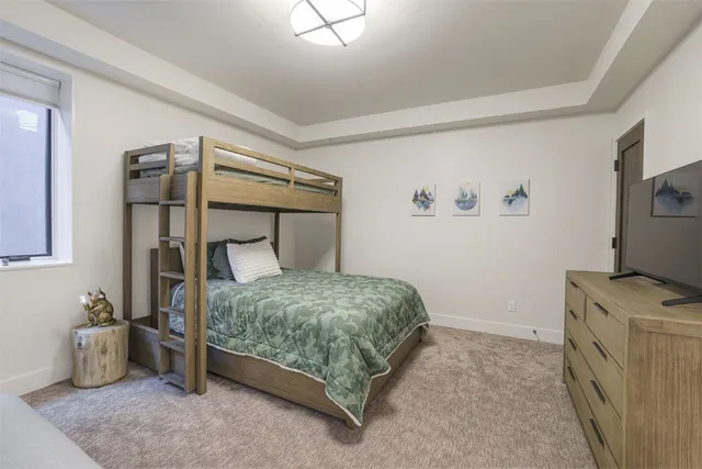 a bedroom with a bed and a flat tv screen on the dresser