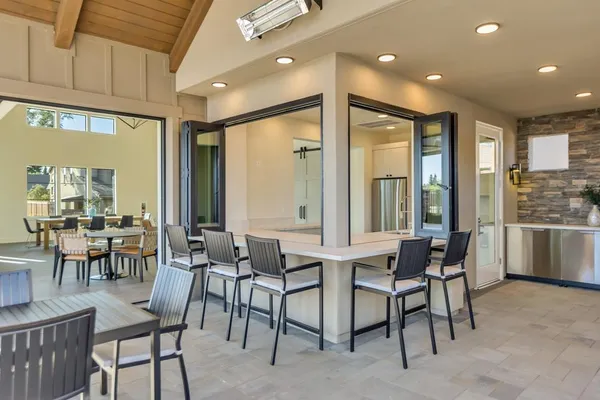 a dining hall with stainless steel appliances a dining table and chairs