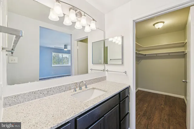 a bathroom with a granite countertop sink and a mirror