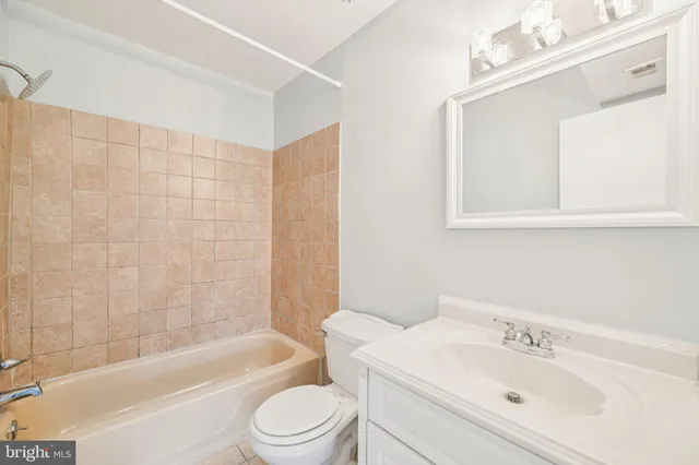 a bathroom with a bathtub shower sink vanity and toilet