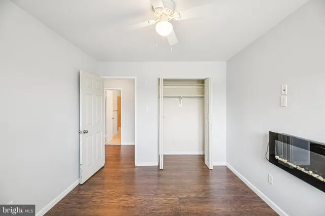 wooden floor in an empty room with a chandelier fan