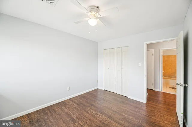 a view of a room with wooden floor and a ceiling fan