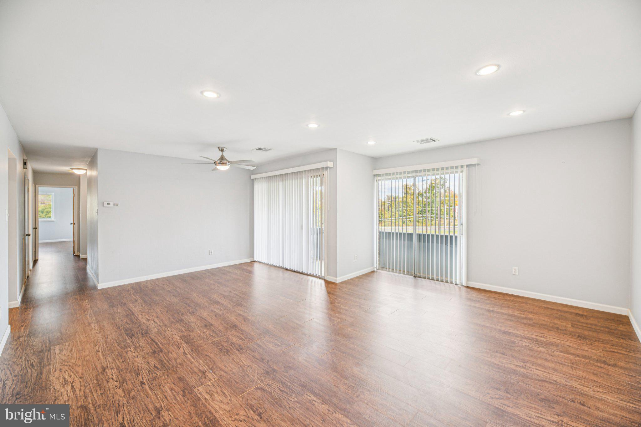 10216 Prince Place, Unit 9202 Upper Marlboro, MD 20774 - Photo 5 of 32 a view of an empty room with wooden floor and a window
