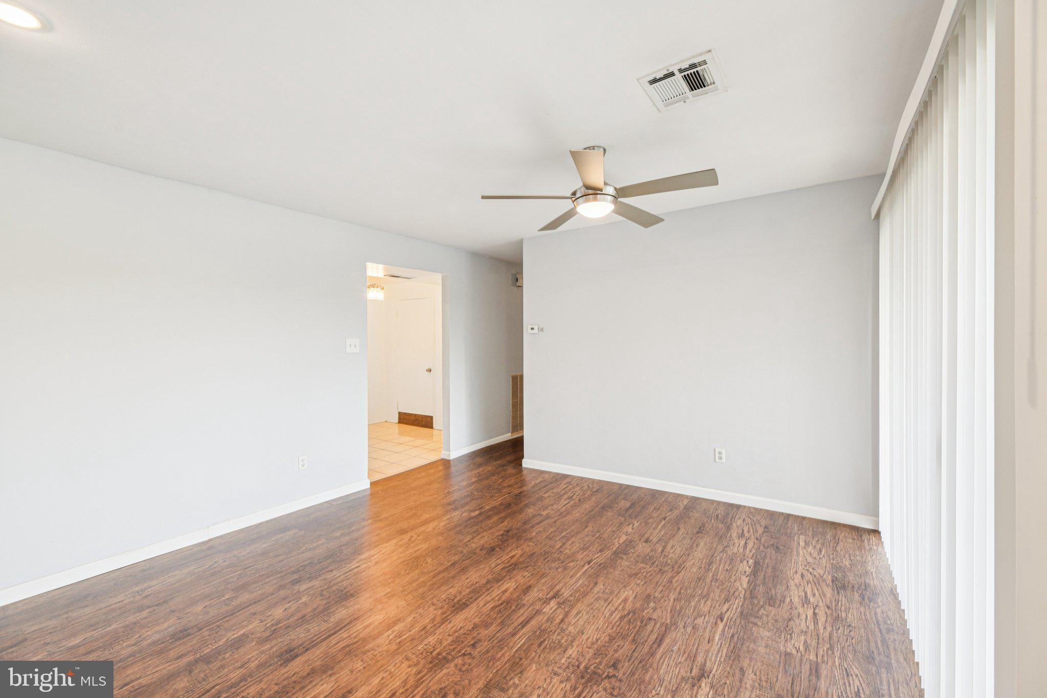 10216 Prince Place, Unit 9202 Upper Marlboro, MD 20774 - Photo 7 of 32 a view of an empty room with wooden floor
