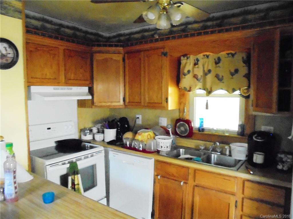 108 Howell Road Marshall, NC 28753 - Photo 22 of 26 a kitchen with stainless steel appliances granite countertop a sink a stove and a wooden cabinets