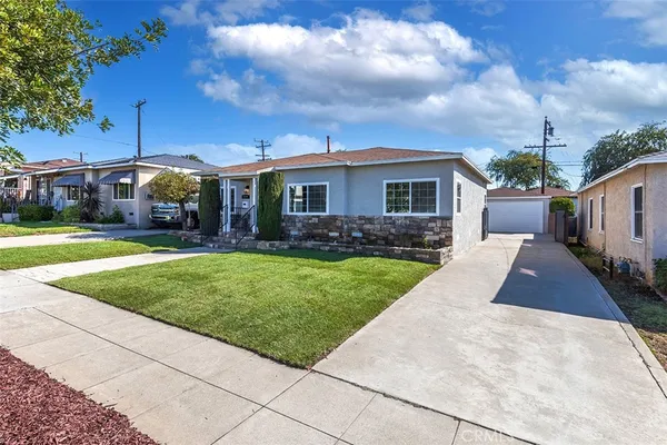 a front view of a house with a yard and potted plants