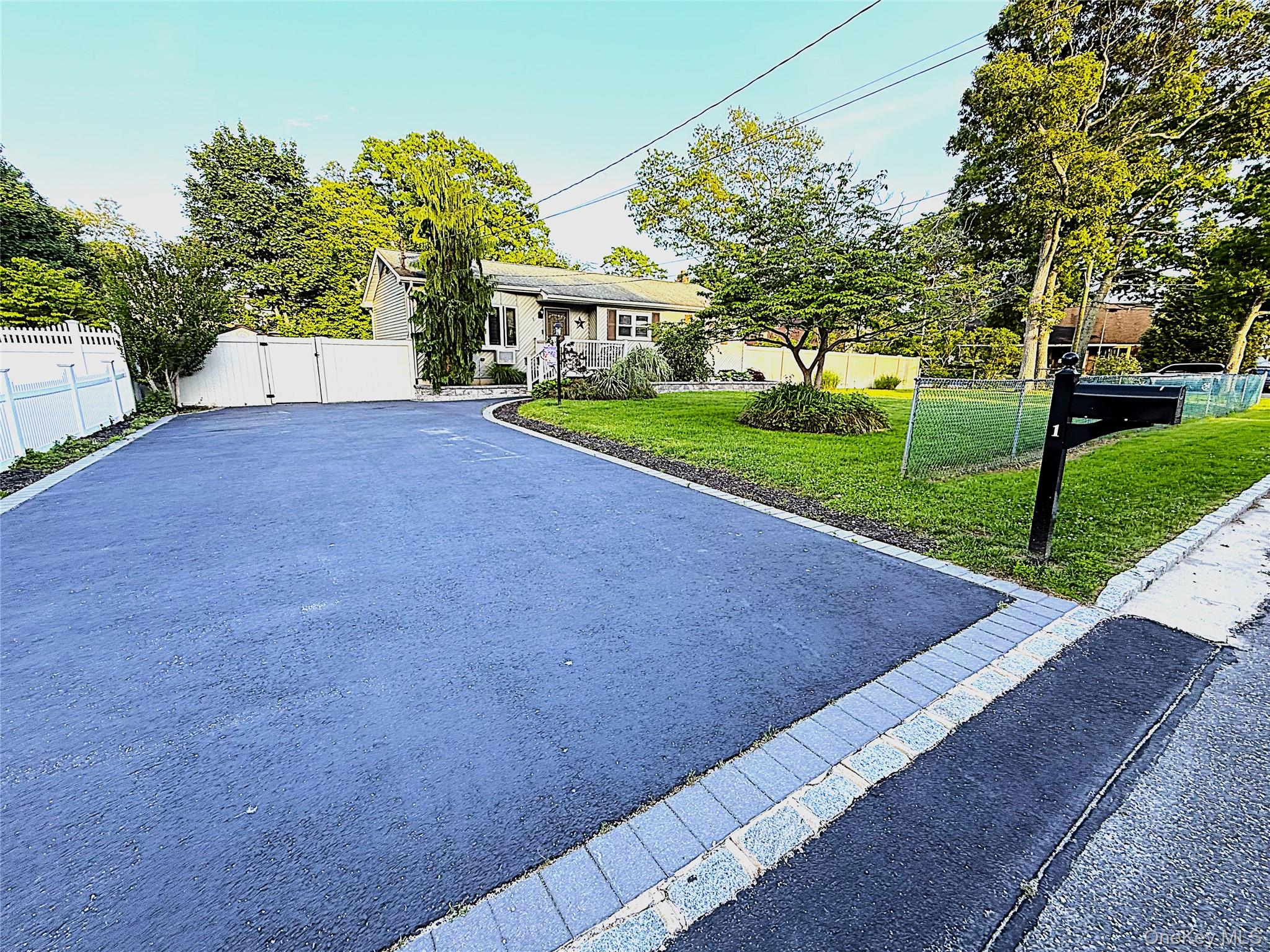 1 Heston Road Shirley, NY 11967 - Photo 4 of 32 Expansive asphalt driveway featuring paver edging and a white vinyl fence with double gates