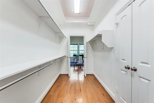 a hallway with wooden floor table and chairs