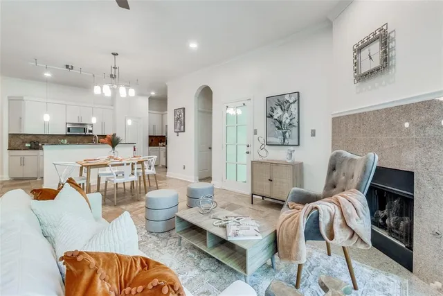 a living room with furniture a fireplace and kitchen view
