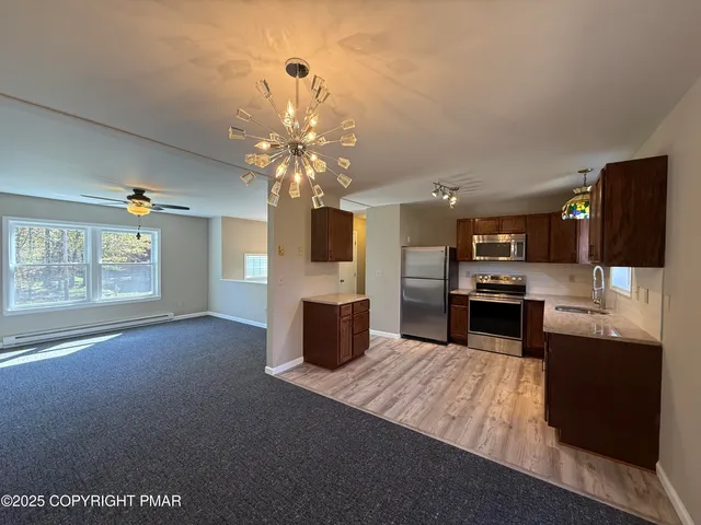 a large kitchen with a table chairs and refrigerator