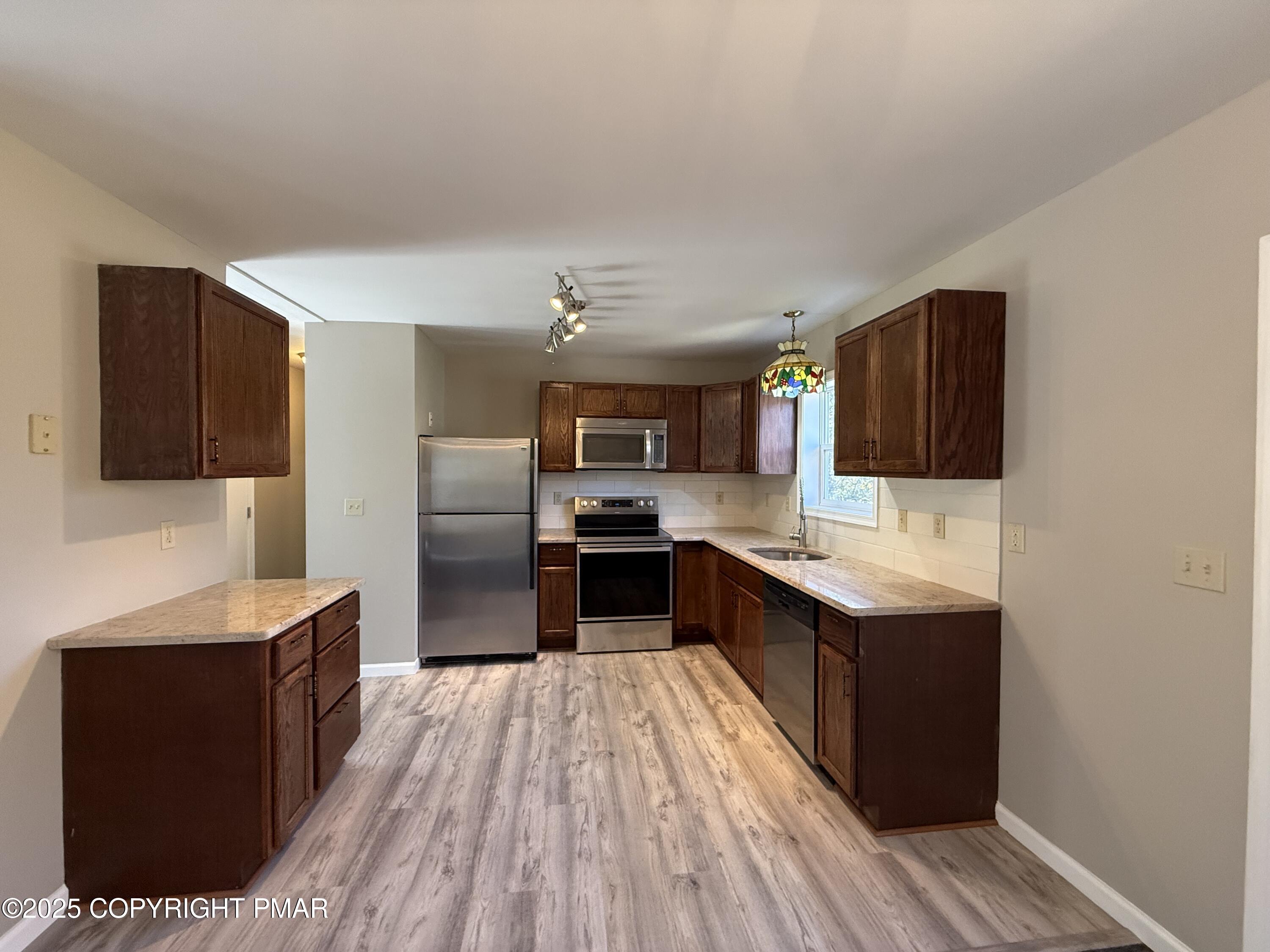 1753 Rolling Hills Drive Tobyhanna, PA 18466 - Photo 6 of 25 a large kitchen with stainless steel appliances granite countertop a large counter top and a stove