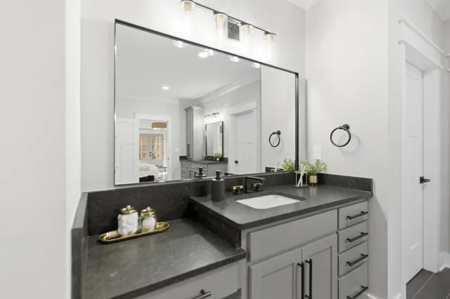 a bathroom with a granite countertop sink and a mirror