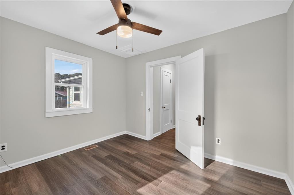 132 Victory Drive Monroe, GA 30655 - Photo 21 of 36 a view of an empty room with wooden floor and a window