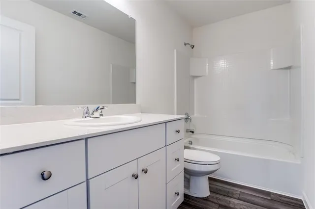 a bathroom with a double vanity sink toilet and shower