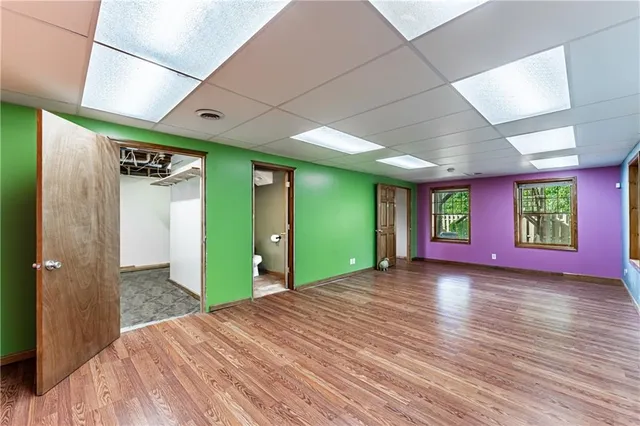 a view of a hallway with wooden floor and a window