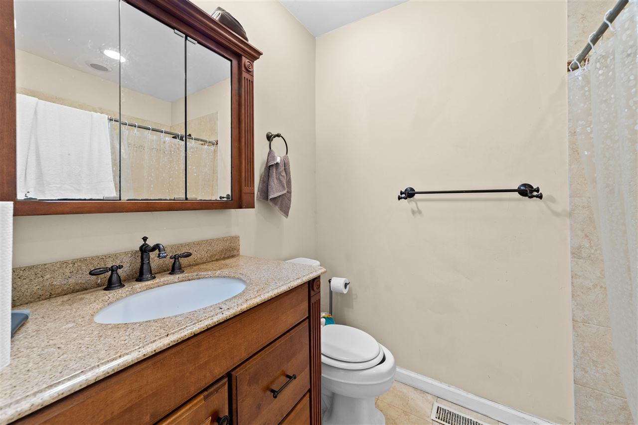 407 Brooks Avenue Raleigh, NC 27607 - Photo 16 of 30 a bathroom with a granite countertop sink toilet and shower