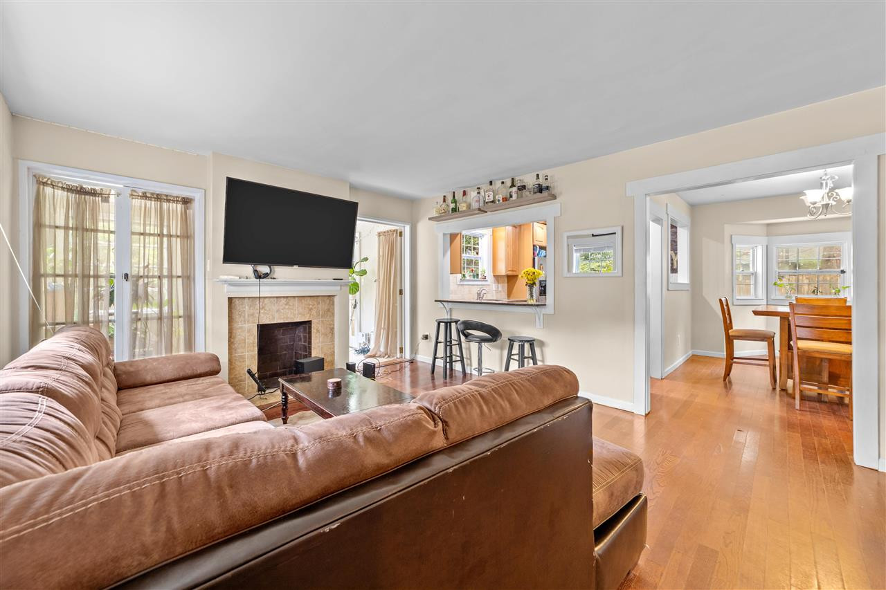 407 Brooks Avenue Raleigh, NC 27607 - Photo 23 of 30 a living room with furniture a fireplace and a flat screen tv