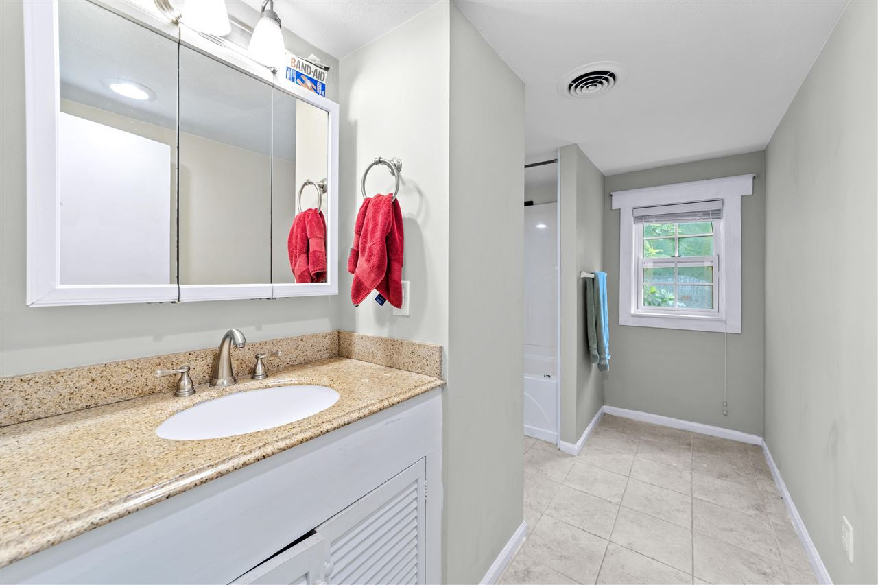 407 Brooks Avenue Raleigh, NC 27607 - Photo 27 of 30 a bathroom with a granite countertop sink and a mirror
