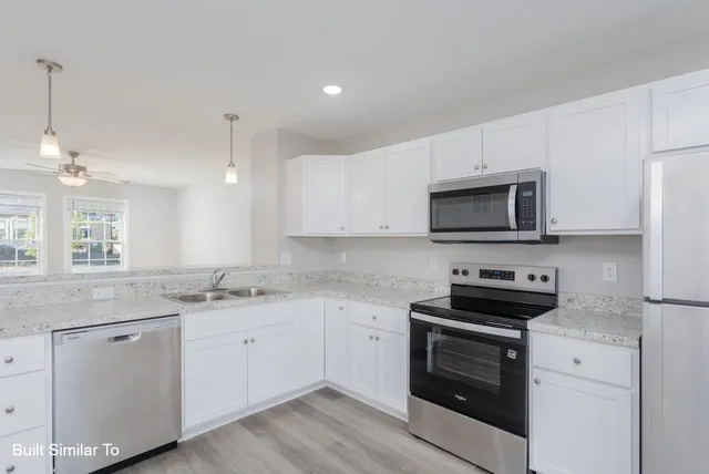 a kitchen with white cabinets sink and stainless steel appliances