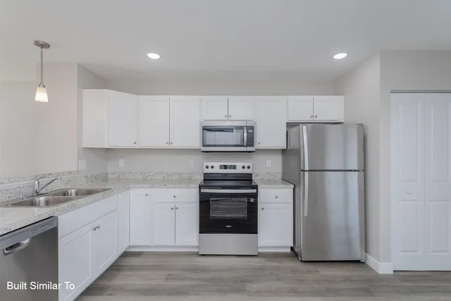 a kitchen with a refrigerator sink and cabinets