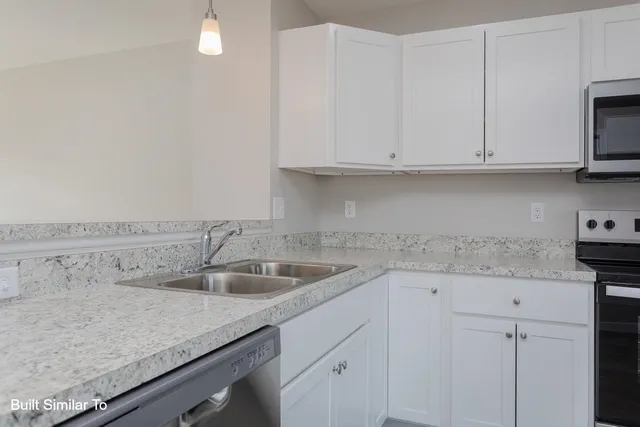 a kitchen with granite countertop white cabinets and a sink