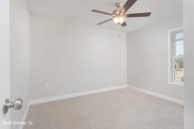 an empty room with a window and a fan
