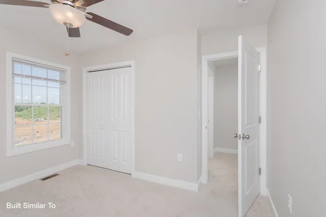 an empty room with a fan and a fan