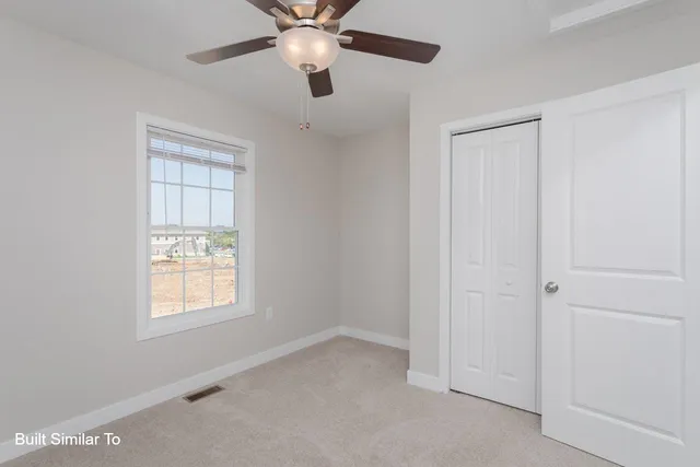an empty room with chandelier fan