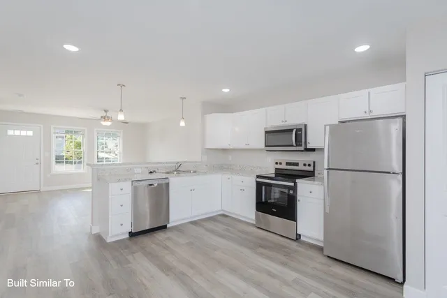 a kitchen with stainless steel appliances a refrigerator sink and stove top oven