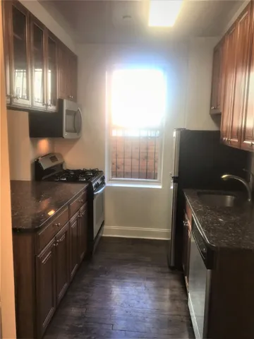 a kitchen with granite countertop a stove and a sink