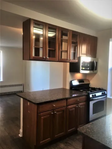 a kitchen with stainless steel appliances granite countertop a stove a sink and a microwave