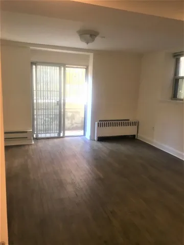 a view of a livingroom with wooden floor and a window