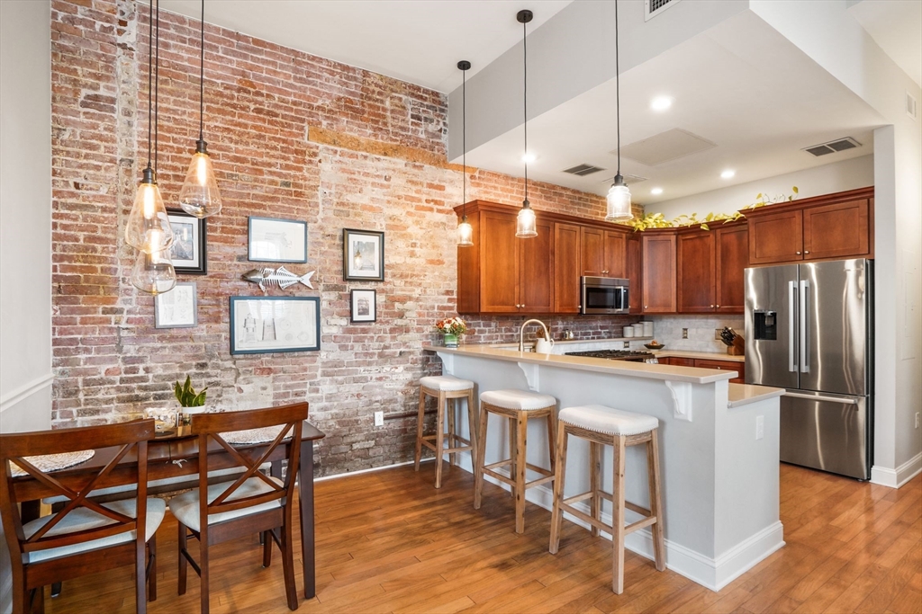 68 Baldwin Street, Unit 1 Boston, MA 02129 - Photo 1 of 19 a kitchen with kitchen island a dining table chairs and a refrigerator