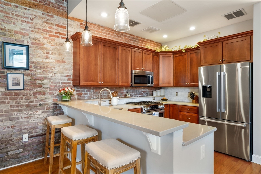 68 Baldwin Street, Unit 1 Boston, MA 02129 - Photo 6 of 19 a kitchen with stainless steel appliances a refrigerator a sink a stove a dining table and chairs