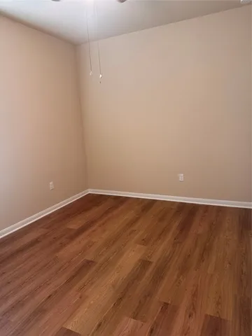 an empty room with wooden floor and a window