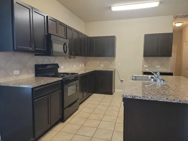 a kitchen with stainless steel appliances granite countertop a sink and a stove top oven