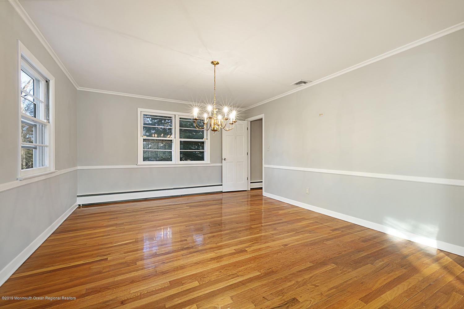 2 Old Farm Road Colts Neck, NJ 07722 - Photo 11 of 56 an empty room with wooden floor chandelier and windows