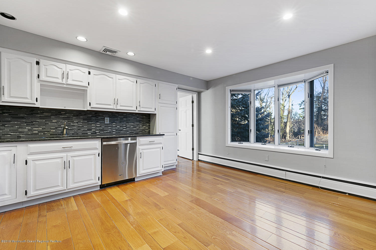 2 Old Farm Road Colts Neck, NJ 07722 - Photo 20 of 56 a kitchen with granite countertop a stove a sink and white cabinets with wooden floor