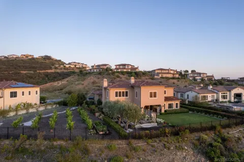 an aerial view of residential houses with outdoor space and trees