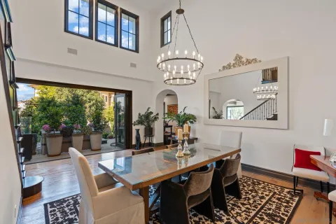 a dining room with wooden floor a chandelier a wooden table and chairs