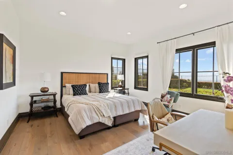 a bedroom with a bed and large windows