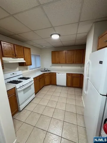 a large kitchen with stainless steel appliances granite countertop a stove a sink dishwasher and a refrigerator