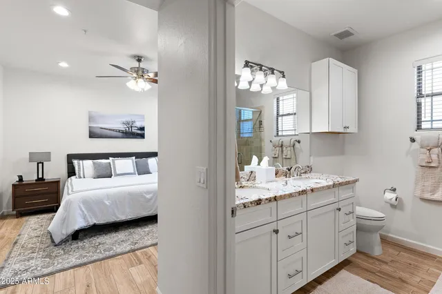 a bathroom with a granite countertop sink a toilet and mirror