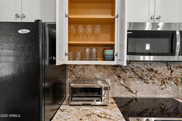 a kitchen with granite countertop a stove and a microwave