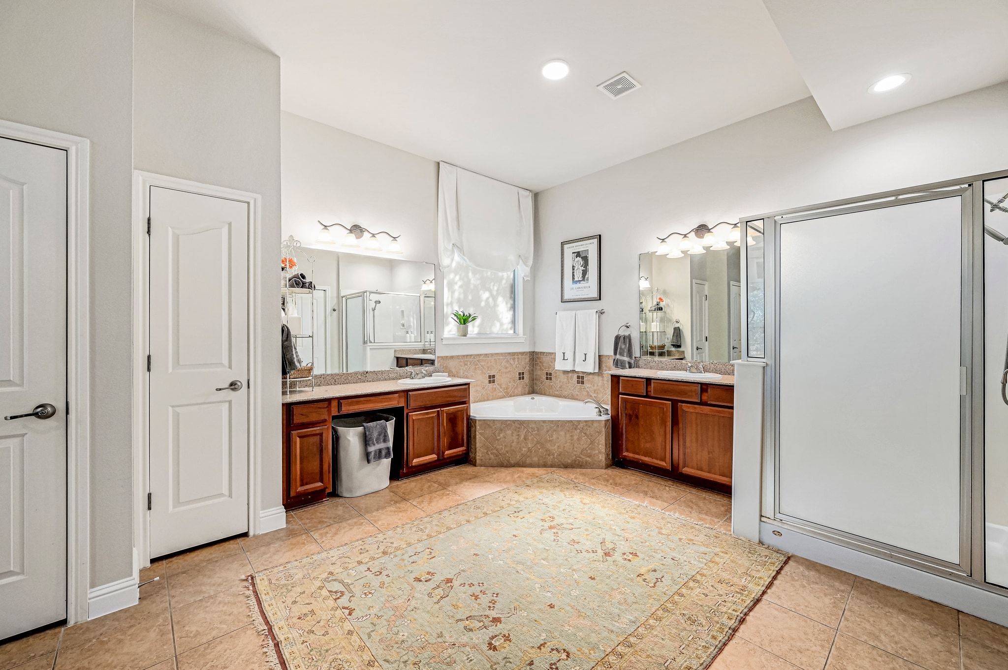 7112 Via Correto Drive Austin, TX 78749 - Photo 12 of 29 Bathroom with a stall shower, a garden tub, two vanities, and light tile patterned floors