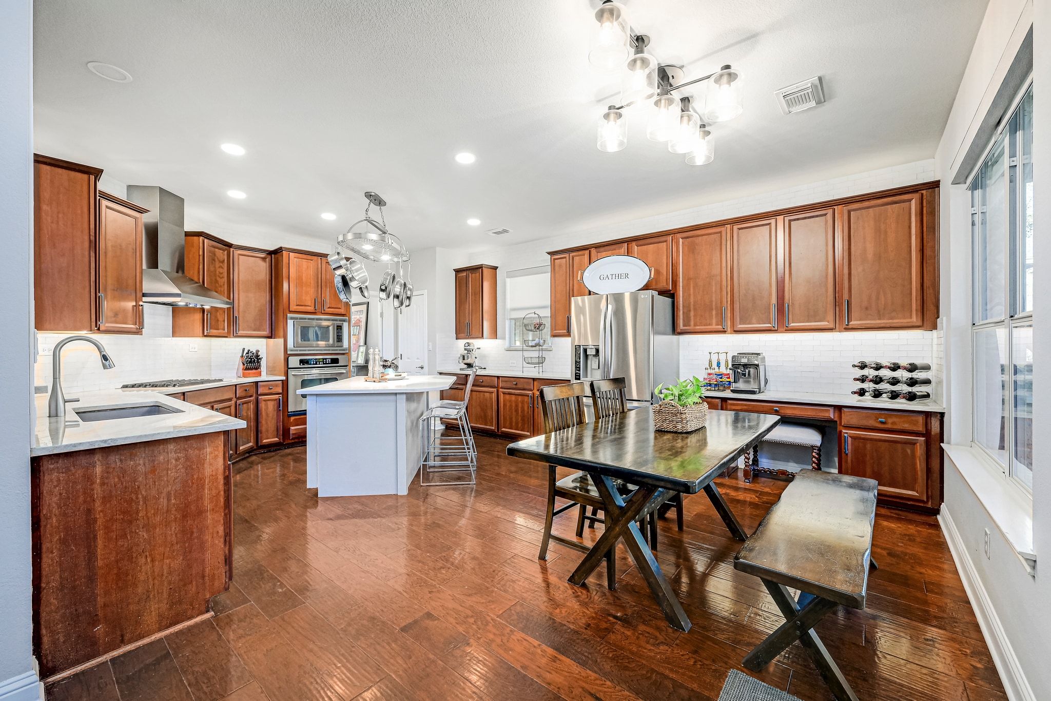 7112 Via Correto Drive Austin, TX 78749 - Photo 7 of 29 Kitchen with dark wood-type flooring, wood finish cabinets, hanging light fixtures, stainless steel appliances, and a center island