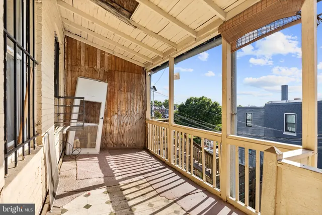 a view of a balcony with wooden floor and iron fence