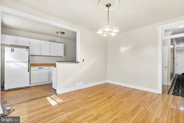 a view of a kitchen with wooden floor and a refrigerator