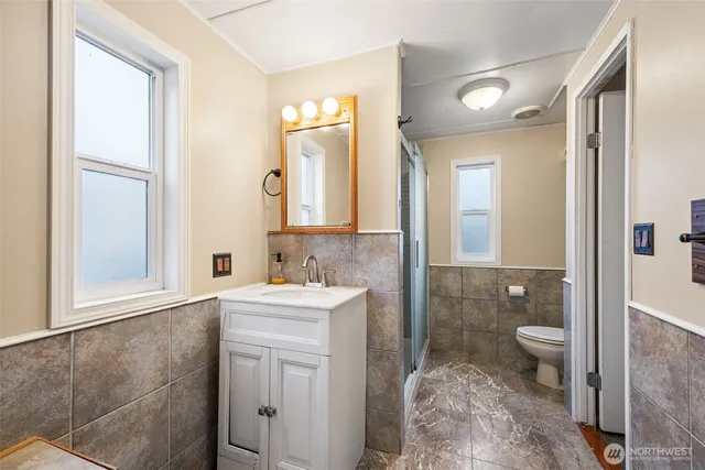 a bathroom with a sink a toilet and shower